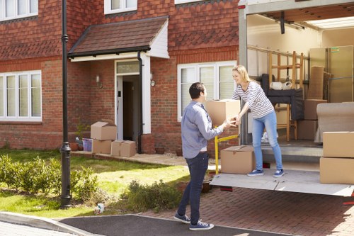 Removal team preparing furniture with safety equipment during a house move